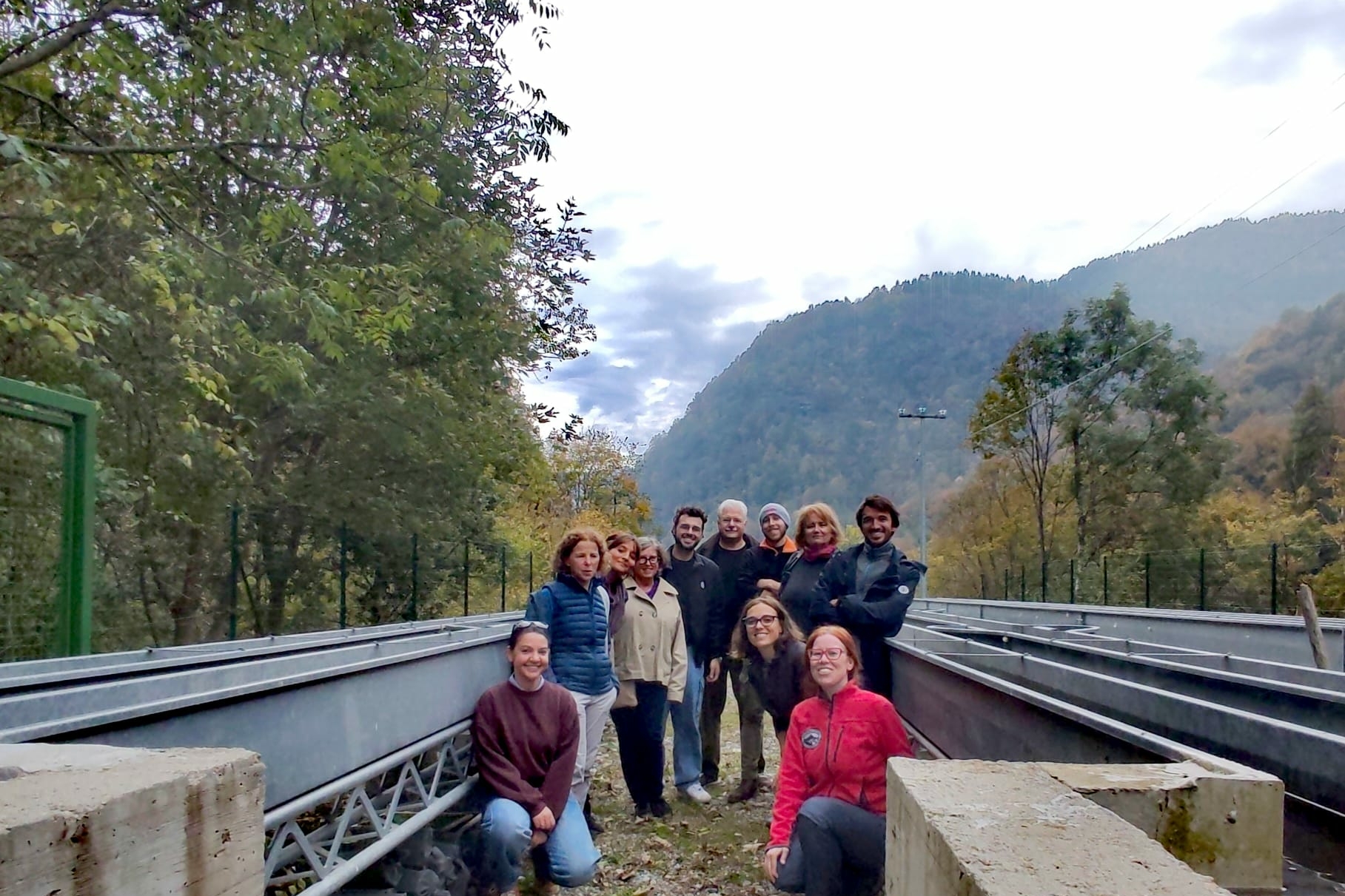 gruppo di persone tra i corpi fluviali artificiali di Ostana