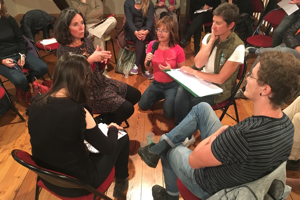 un gruppo di persone sedute in cerchio che parlano tra loro